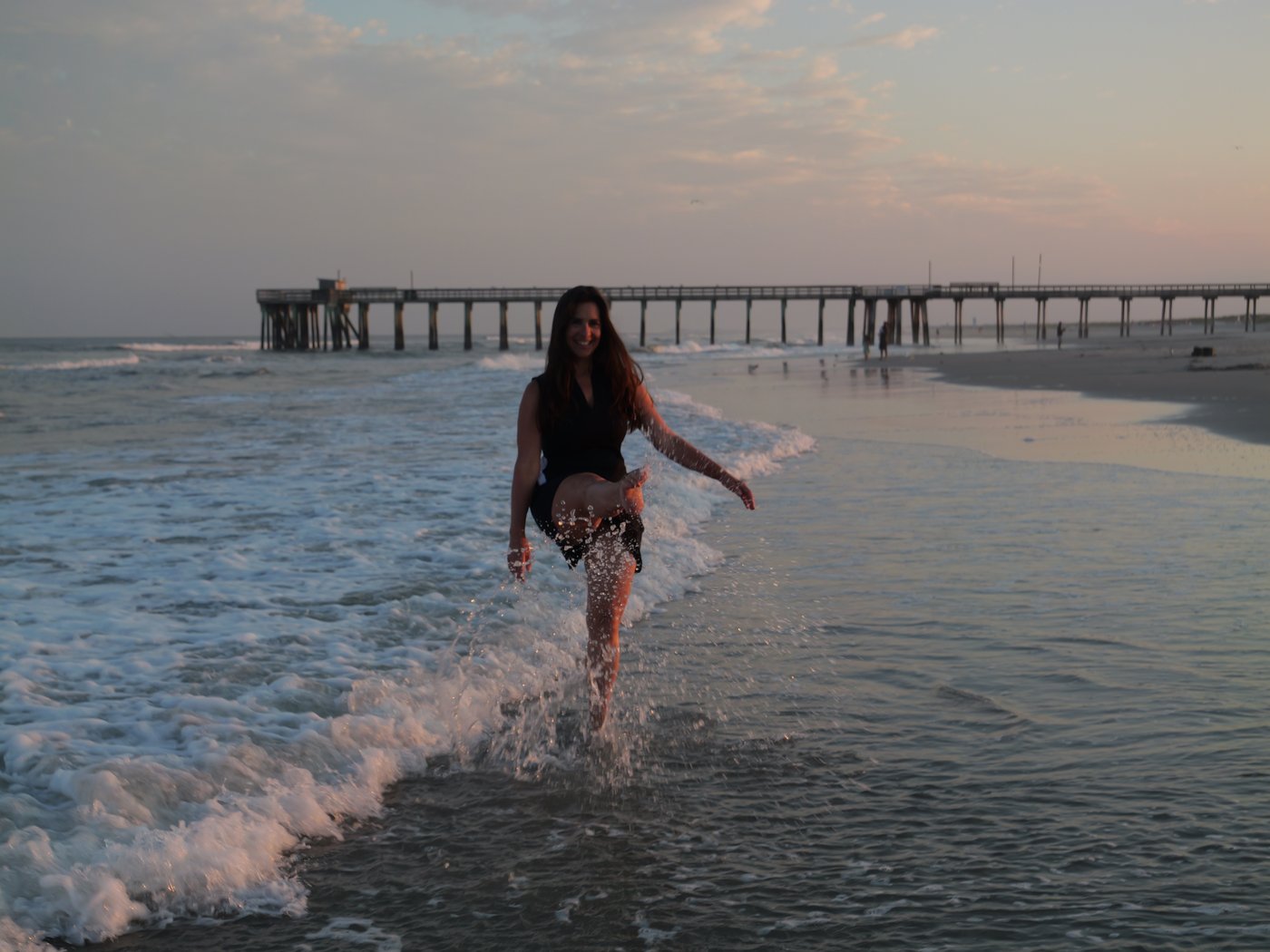 Devin Alexander walking in the ocean at sunset